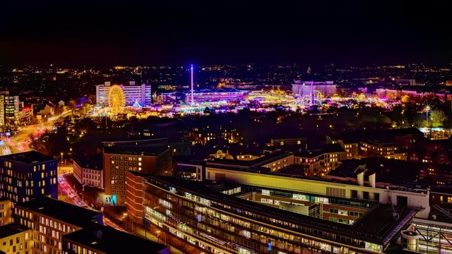 Aerial view of downtown Hamburg, Germany,  and the famous funfair (German: Hamburger Dom), illuminated at night. 4k UHD time lapse video.