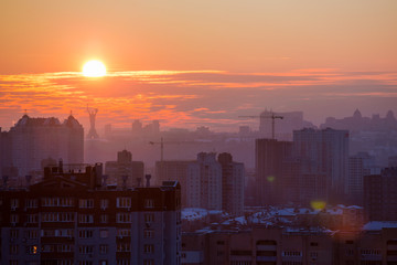 Fototapeta premium Sunset in Kiev, evening view of the panorama of the city, the church and the statue of the Motherland. Evening color urban landscape