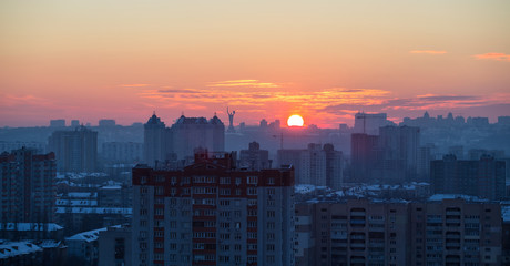 Sunset in Kiev, evening view of the panorama Kiev city. Red sun, fog and smog in the capital of Ukraine