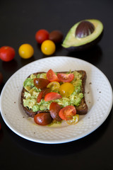 Healthy green veggie avocado toast with tomatoes