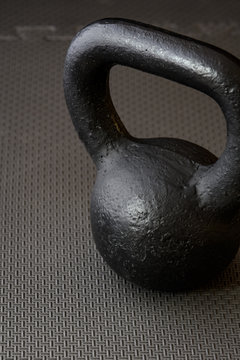 Black kettlebell on a black gym floor, simple commitment to fitness
