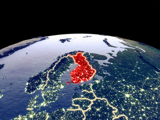 Finland from space on planet Earth at night with bright city lights. Detailed plastic planet surface with real mountains.