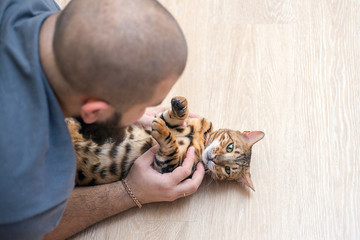 a man is playing with his cat