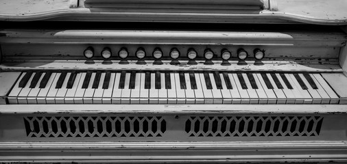 Fototapeta na wymiar Partial front on, topside view of painted antique pump organ keyboard
