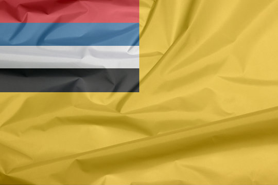 Fabric flag of the Empire of Manchuria. Crease of Manchukuo flag background, mustard yellow field with four horizontal stripes.
