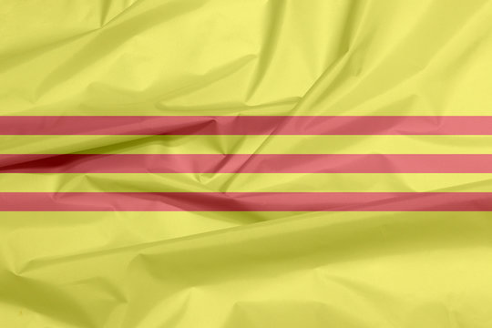 Fabric flag of South Vietnam or Republic of Vietnam. Crease of Heritage and Freedom flag background,  yellow with three red stripes.