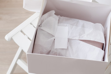 White opened box with wrapping paper and label