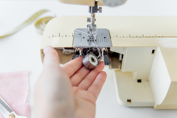female hands are using a sewing machine