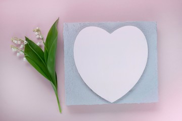 Flower card.Card with heart and flowers. lily of the valley flower and pink heart  on a pink pastel background.Valentine's Day. Mothers Day. International Women's Day