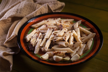 pasta with minced meat, garlic and onion in navy-style on yellow wooden table. Makarony po-flotski, Russian dish