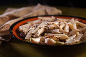pasta with minced meat, garlic and onion in navy-style on yellow wooden table. Makarony po-flotski, Russian dish