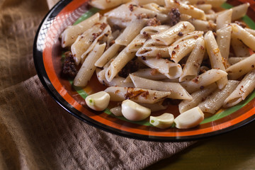 pasta with minced meat, garlic and onion in navy-style on yellow wooden table. Makarony po-flotski, Russian dish