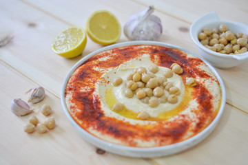 plate of Traditional  homemade hummus on rustic table background with red paprika olive oil ,garlic ,  lemon ,  tahini and  pita bread  Image