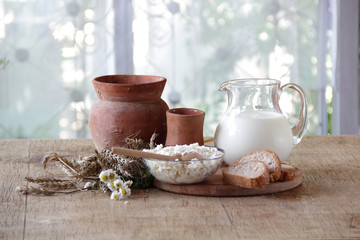 Milk in a transparent jug and cottage cheese