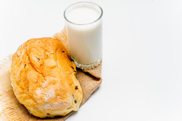 a glass of milk with bread and grains