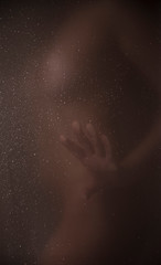 Obraz na płótnie Canvas woman in the shower through the glass.