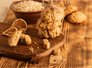 Homemade oatmeal cookies on wooden board on old table background
