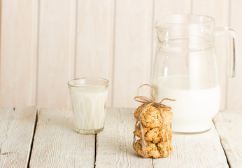 Oatmeal cookies with milk on tray on rustic wooden table