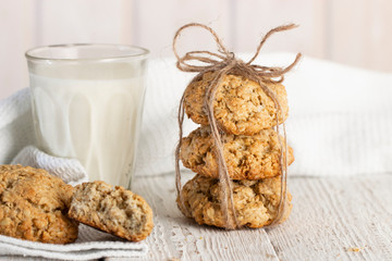 Oatmeal cookies with milk on tray on rustic wooden table
