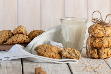 Oatmeal cookies with milk on tray on rustic wooden table