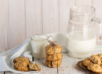 Oatmeal cookies with milk on tray on rustic wooden table