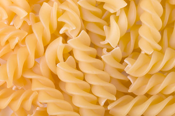 Raw fusilli pasta uncooked closeup. Food background. Top view