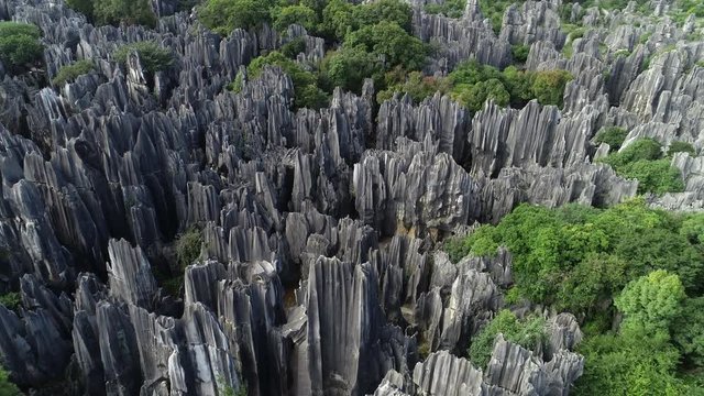 Tilted aerial footage of impressive Shilin Stone Forest, unusual natural scenery in China
