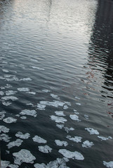 Dark water and cracked ice on the river surface