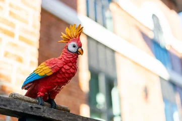 Gordijnen parrot made of wood for home decoration with soft-focus and over light in the background © memorystockphoto