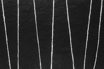 Abstract composition of white thread on black stone background surface
