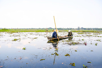 Udontani Province, THAILAND - APRIL 14, 2018: Fisherman are fishing by small boat in the large lotus pond