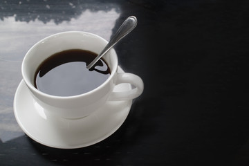 Top view of hot coffee in white ceramic cup, black and white tone