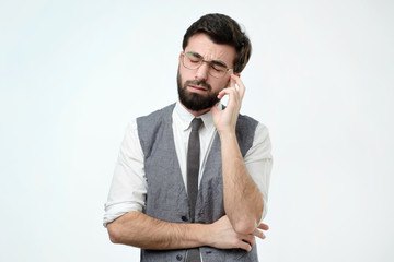 Portrait of a pensive spanish man in white shirt against a white background. He is trying to make a decision.