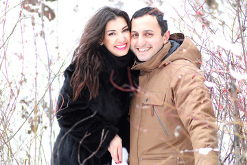 A young couple walk in a winter park