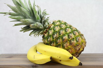 Ananas z bananami na jasnym tle - zdrowe owoce pełne witamin