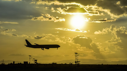 takeoff of the plane on the airfield against the background of the bright sun and beautiful cloudy...