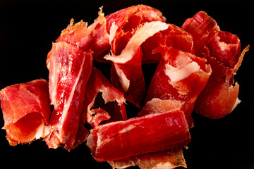 Serrano ham cut on black background.