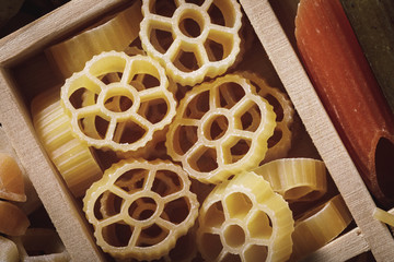 Closeup of pasta in a wooden box, top view