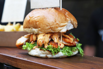 close up of a delicious burger with chicken, sauce and fresh lettuce - delicious street food