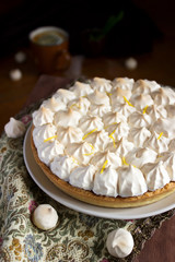 Lemon meringue cake served with tea on a dark background. Rustic style.