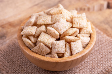 Crispy corn pads in wooden bowl with burlap napkin