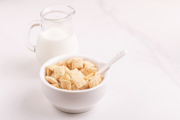 Crispy corn pads in bowl with jar of fresh milk