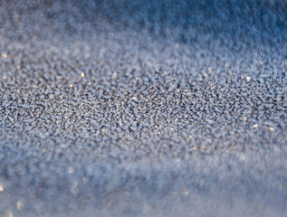 small ice crystals frozen black surface