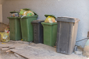 Gefüllte Mülleimer stehen in einer Hofeinfahrt