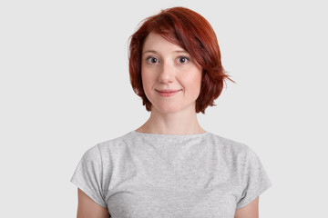 Beautiful red haired woman with minimal make up, dressed in casual t shirt, has appealing...
