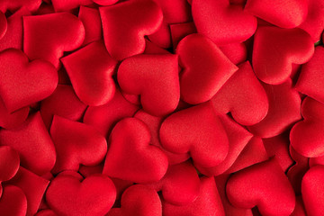 Valentine's Day. Red heart shape backdrop. Abstract holiday Valentine background with red satin hearts. Love concept