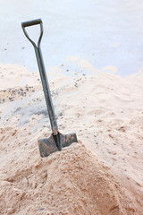 construction site with shovels on pile of sand.
