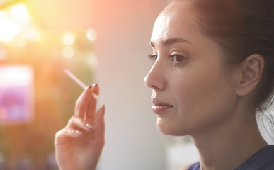 Obraz premium Woman enjoying her cigarette in the morning outdoors. Girl smoking a cigarette close up