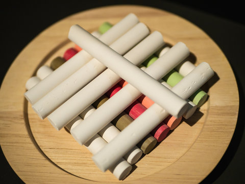 Pieces of white and colorful chalk on a plate