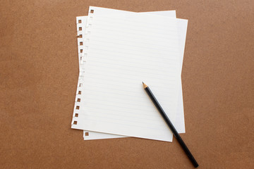 blank paper with black pencil on wooden background. soft focus.